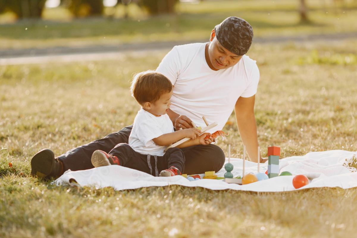 Man playing with child on blanket
